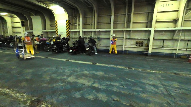新日本海フェリー船内で係の人に誘導されて指定された場所にバイクを停めようとしている画像