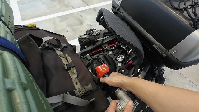 NC750Xのリアシートを跳ね上げてガソリンスタンドで給油している画像。