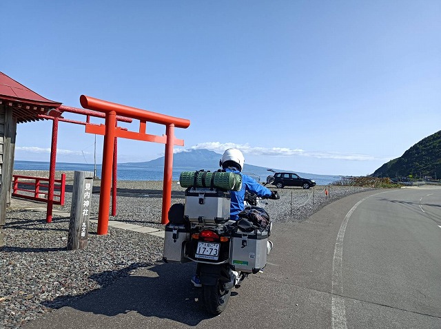 8月の礼文島の早朝にレインジャケットを着てバイクに乗る男性