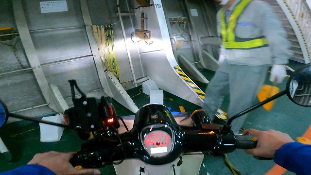 南海フェリーのフェリー内のバイク固定位置にライダーが誘導されている画像