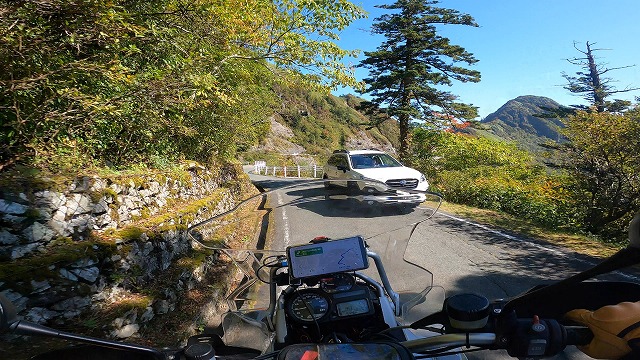 R1200GSAというバイクでUFOラインの狭い道で車とすれ違おうとしている